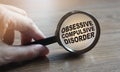 Diagnosis of Obsessive Compulsive Disorder under magnifying glass in hand. Causes, symptoms, diagnosis and treatment of this Royalty Free Stock Photo