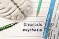 Diagnosis Psychosis. Figure of human brain, result of mental status exam, pen and pencil surrounded written psychiatric diagnosis