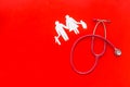 Diagnostic and cure of cardiac disease with stethoscope and family paper figures on red background top view mock-up