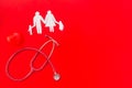 Diagnostic and cure of cardiac disease with stethoscope and family paper figures on red background top view mock-up