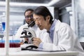 Diagnostic laboratory manager using microscope to evaluate cellular structures Royalty Free Stock Photo