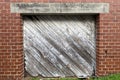 Diagonal faded wooded shipping receiving loading dock door red brick building alley Royalty Free Stock Photo