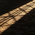 Diagonal light casts shadows of a window frame on a textured brick floor Royalty Free Stock Photo