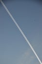 A diagonal line of smoke against the blue sky. A trace of an airplane Royalty Free Stock Photo