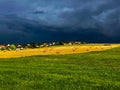 Diagonal lines and hay bales at the countryside Germany. dark sky before a thunderstorm, a field with golden oats