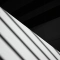 Diagonal lines of light and shadow create a dramatic contrast across a white surface. Royalty Free Stock Photo