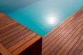 Diagonal lines of wood in detail decking and blue water swimming pool abstract background Royalty Free Stock Photo