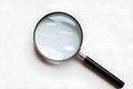Diagonal magnifying glass with shiny metallic frame, plain white background emphasizes simplicity Royalty Free Stock Photo