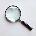 Diagonal magnifying glass with shiny metallic frame, plain white background emphasizes simplicity Royalty Free Stock Photo