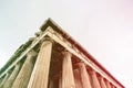 Diagonal minimalistic view of Greek ruin with doric columns. Colored light leaks on the side. Royalty Free Stock Photo