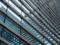 Diagonal perspective view of the facade of a modern glass commercial building with steel frames and sky reflected in the windows Royalty Free Stock Photo