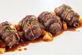 Diagonal row of beef roulades in gravy