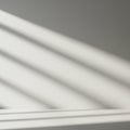 Diagonal shadows from blinds cast across a smooth, light gray surface. The shadows Royalty Free Stock Photo