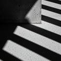 Diagonal shadows cast by a structure create a striking pattern on a textured concrete