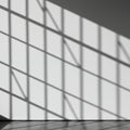 Diagonal shadows from a grid-like structure cast across a white wall, creating a Royalty Free Stock Photo
