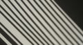 Diagonal shadows of parallel lines cast on a surface, creating a pattern of alternating light and Royalty Free Stock Photo