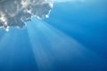 Diagonal sunbeam on a blue sky under a cloud Royalty Free Stock Photo
