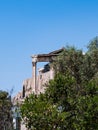 Diagonal view of a Greek ancient arch. Remains of an old temple stand against a deep blue sky in the background. Typical