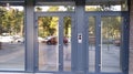 Diagonal view of modern building wall with bif glass window and door with blue frame. Street reflection. Royalty Free Stock Photo