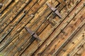 Diagonal view of rusty hinges on a woodgrain background Royalty Free Stock Photo
