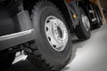 Diagonal view on tipper truck wheels and tires with blured background. Truck wheel rim. Truck chassis exhibit on car Exhibition. C
