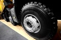 Diagonal view on tipper truck wheels and tires with blured background. Truck wheel rim. Truck chassis exhibit on car Exhibition. C