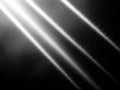 Diagonal white light beams shining through darkness with subtle particles Royalty Free Stock Photo