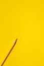 Diagonal yellow sharp wooden pencil on a bright yellow background, isolated, copy space, mock up