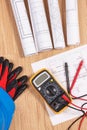 Electrical diagrams, protective helmet with gloves and multimeter for measurement in electrical installation Royalty Free Stock Photo