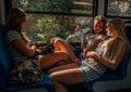 Three young girls in sunset lighting traveling in train car and their reflections in window