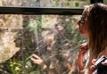 Young girl in sunset lighting traveling in train car and her reflection in window