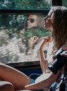 Young girl in sunset lighting traveling in train car and her reflection in window Royalty Free Stock Photo