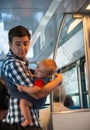 Young man and his little baby in sling in sunset lighting traveling in train car