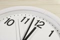 Dial of an analog clock close up on a wooden background. The time is 23:59. White dial, black numerals Royalty Free Stock Photo