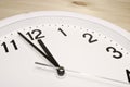 Dial of an analog clock close up on a wooden background. The time is 23:59. White dial, black numerals Royalty Free Stock Photo