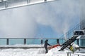 Dialerets, Valais Switzerland -21.10.2020: Man in black with a red snow blowing machine working in winter day beside glass