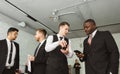 Dialogue of two men with with smartphones young businessmen in suits working and communicating together in an office Royalty Free Stock Photo