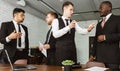 Dialogue of two men at work, young businessmen in suits working and communicating together in an office. Corporate Royalty Free Stock Photo