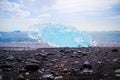 Diamond Beach in Iceland with blue icebergs melting on black sand and ice glistening with sunlight