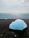 Diamond Beach in Iceland with blue icebergs melting on black sand and ice glistening with sunlight