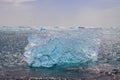 Diamond Beach in Iceland with blue icebergs melting on black sand and ice glistening with sunlight