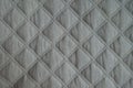 Diamond pattern on white quilted fabric from above