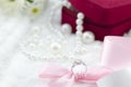 Diamond ring and pink ribbon on pearl necklace background Royalty Free Stock Photo