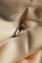 Diamond ring with ruby gemstone on beige satin background Royalty Free Stock Photo
