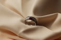 Diamond ring with ruby gemstone on beige satin background Royalty Free Stock Photo