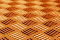 Diamond shaped metal floor pattern with blur in orange tone. Royalty Free Stock Photo