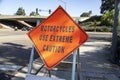 A diamond shaped road sign advising motorcycle riders to use extreme caution