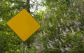 Diamond yellow sign in the park with lilac in blossom