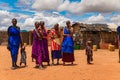 Maasai women in traditional dress communicate with each other and laugh