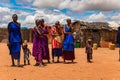 Maasai women in traditional dress communicate with each other and laugh